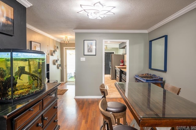 12 Wickford Ln, Little Rock, AR 72212 - dining area featuring light wood-type flooring, a textured ceiling, ornamental molding, baseboards, and a chandelier