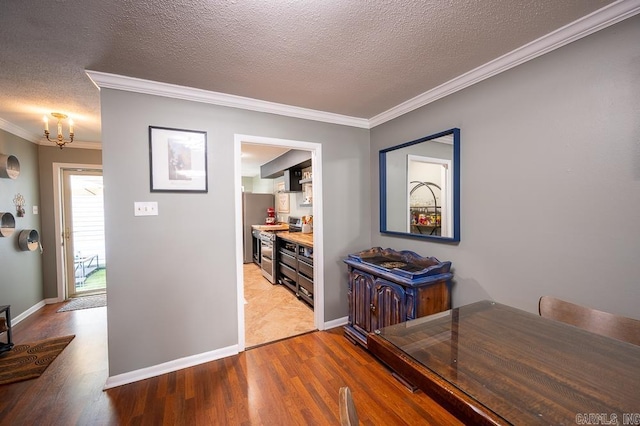 12 Wickford Ln, Little Rock, AR 72212 - dining area featuring wood finished floors, a chandelier, crown molding, baseboards, and a textured ceiling