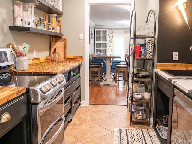 12 Wickford Ln, Little Rock, AR 72212 - kitchen featuring double oven range, butcher block countertops, light tile patterned floors, open shelves, and crown molding