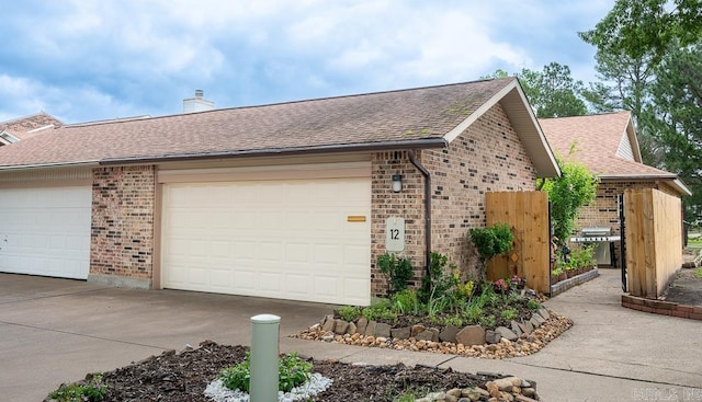 12 Wickford Ln, Little Rock, AR 72212 - view of home's exterior with brick siding, a shingled roof, and a chimney