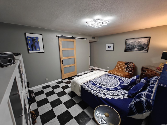 12 Wickford Ln, Little Rock, AR 72212 - bedroom with a barn door, a textured ceiling, tile patterned floors, and baseboards