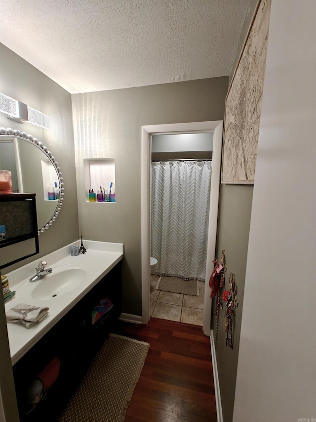 12 Wickford Ln, Little Rock, AR 72212 - full bath with wood finished floors, vanity, a textured ceiling, and toilet