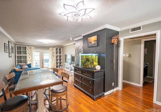 12 Wickford Ln, Little Rock, AR 72212 - dining room with french doors, a textured ceiling, crown molding, wood finished floors, and baseboards