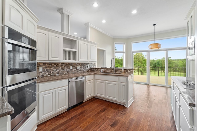 21 Diamante Blvd, Hot Springs Village, AR 71909 - kitchen with stainless steel appliances, a sink, a peninsula, ornamental molding, and decorative backsplash