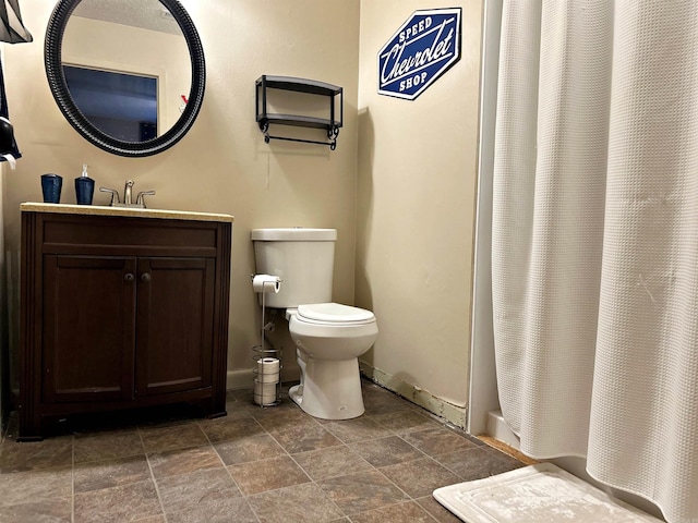 2838 Sylvia St, Arkadelphia, AR 71923 - bathroom featuring vanity, toilet, stone finish flooring, baseboards, and shower / tub combo