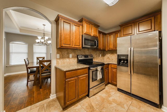 3305 Garden Club Dr, Bryant, AR 72022 - kitchen featuring stainless steel appliances, brown cabinets, decorative backsplash, light stone countertops, and baseboards