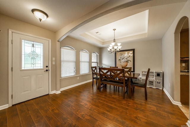 3305 Garden Club Dr, Bryant, AR 72022 - dining space with arched walkways, a tray ceiling, dark wood-style flooring, and baseboards