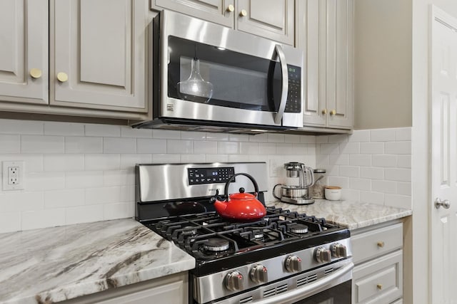 12714 Meadows Edge Ln, Little Rock, AR 72211 - kitchen with appliances with stainless steel finishes, tasteful backsplash, and light stone counters