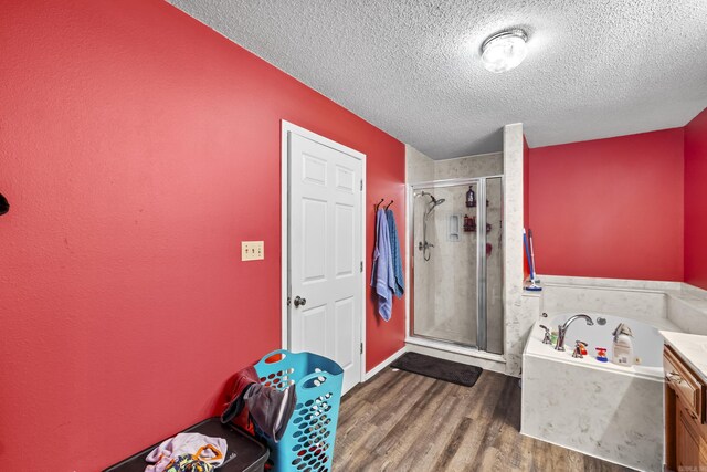 303 Pike Rd, Benton, AR 72019 - bathroom featuring a textured ceiling, a shower stall, a tub with jets, and wood finished floors