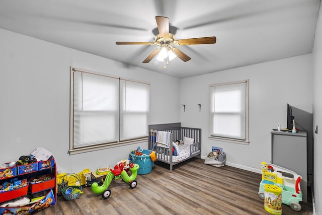 303 Pike Rd, Benton, AR 72019 - unfurnished bedroom with wood finished floors, a nursery area, ceiling fan, and baseboards