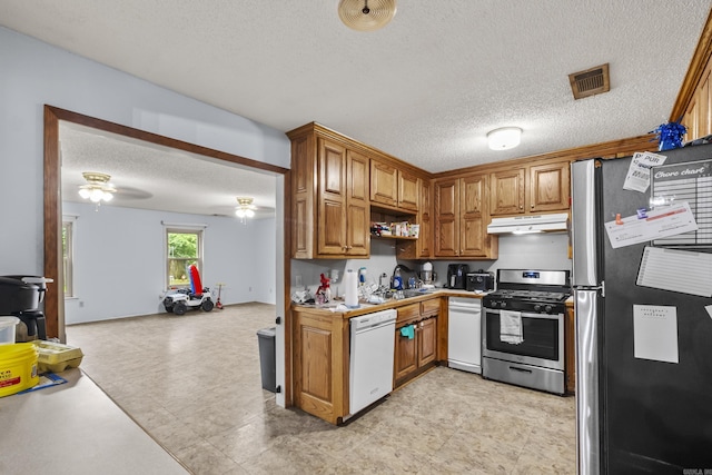 303 Pike Rd, Benton, AR 72019 - kitchen with stainless steel appliances, under cabinet range hood, a sink, a textured ceiling, and open floor plan