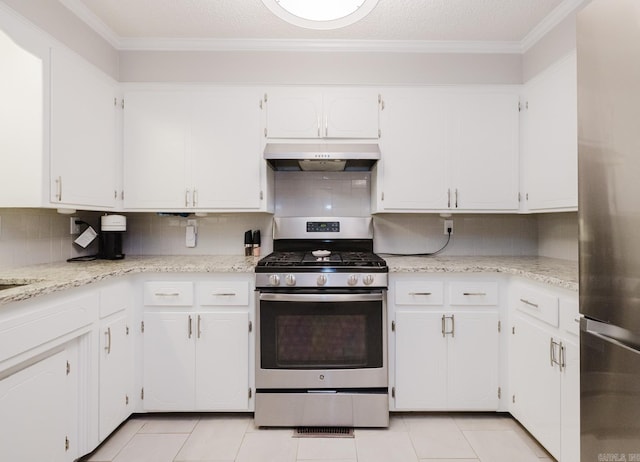 1257 Kimwood Dr, Benton, AR 72019 - kitchen featuring appliances with stainless steel finishes, under cabinet range hood, backsplash, white cabinets, and light tile patterned flooring