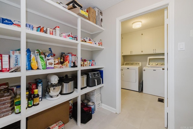 1257 Kimwood Dr, Benton, AR 72019 - laundry area featuring cabinet space, independent washer and dryer, baseboards, and a textured ceiling