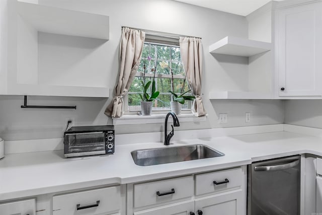 7713 Flintrock Rd, North Little Rock, AR 72116 - kitchen featuring stainless steel dishwasher, a sink, open shelves, white cabinetry, and light countertops