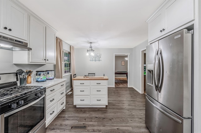 7713 Flintrock Rd, North Little Rock, AR 72116 - kitchen featuring stainless steel appliances, under cabinet range hood, white cabinets, dark wood-style flooring, and a chandelier