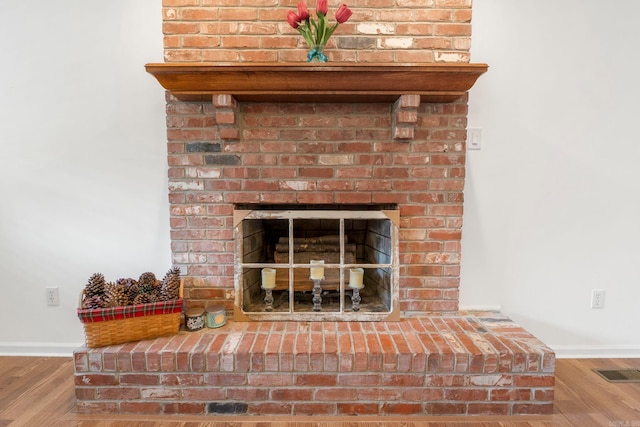 5 Briarstone Dr, Sherwood, AR 72120 - detailed view of baseboards, wood finished floors, and a brick fireplace