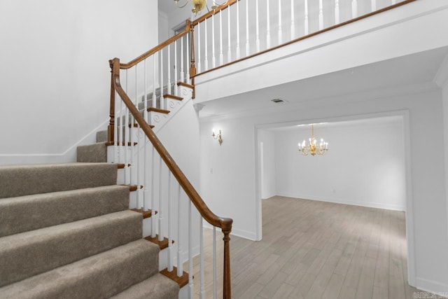 1208 Hilltop Rd, Alexander, AR 72022 - stairway with a chandelier, wood finished floors, baseboards, crown molding, and a high ceiling