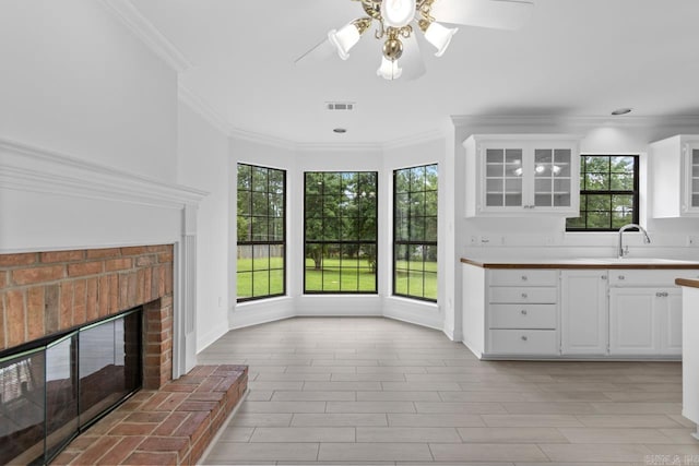 1208 Hilltop Rd, Alexander, AR 72022 - kitchen featuring a sink, light countertops, ornamental molding, glass insert cabinets, and a ceiling fan