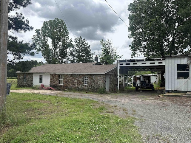 127 Windwood Country Rd, El Paso, AR 72045 - view of front of house featuring driveway, a carport, stone siding, and a chimney