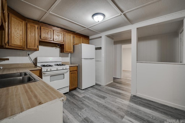 208 King Rd, Benton, AR 72019 - kitchen featuring white appliances, brown cabinetry, a sink, and light wood-type flooring