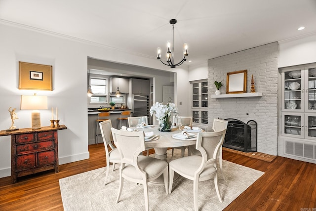 489 Ridgeway Dr, Little Rock, AR 72205 - dining space featuring a chandelier, wood finished floors, crown molding, a fireplace, and recessed lighting