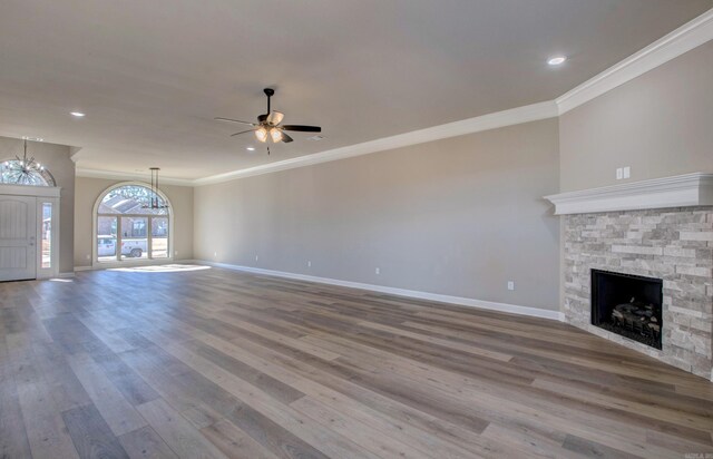 69 Lucia Ln, Maumelle, AR 72113 - unfurnished living room featuring a fireplace, crown molding, wood finished floors, baseboards, and ceiling fan