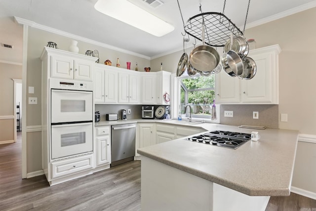 11 Crystal Mountain Ln, Maumelle, AR 72113 - kitchen with white double oven, stainless steel dishwasher, stovetop with downdraft, a peninsula, and a sink