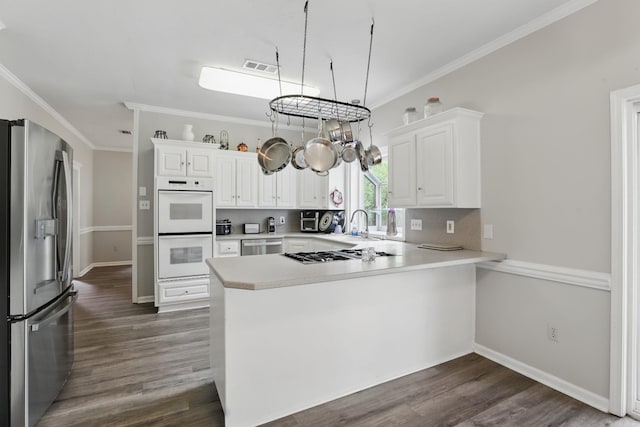 11 Crystal Mountain Ln, Maumelle, AR 72113 - kitchen with stainless steel appliances, a peninsula, light countertops, white cabinets, and crown molding