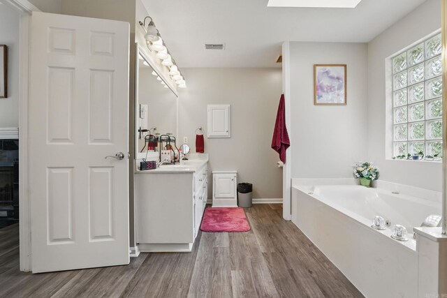 11 Crystal Mountain Ln, Maumelle, AR 72113 - bathroom featuring wood finished floors, vanity, a garden tub, and baseboards