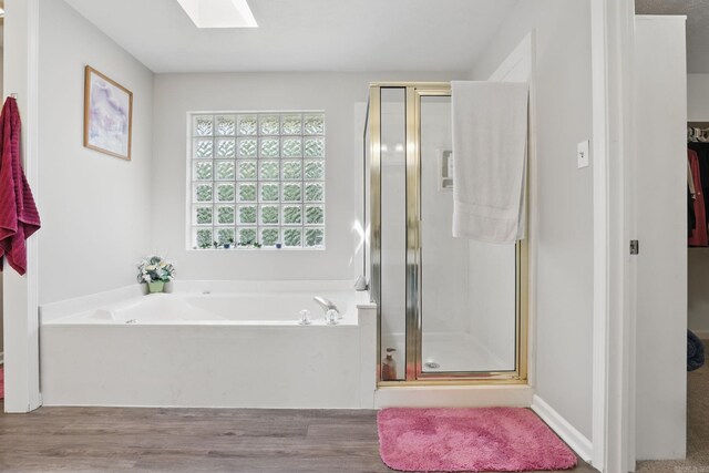 11 Crystal Mountain Ln, Maumelle, AR 72113 - bathroom featuring a skylight, a stall shower, a bath, and wood finished floors
