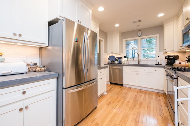 6709 Waverly Dr, Little Rock, AR 72207 - kitchen with appliances with stainless steel finishes, a sink, recessed lighting, white cabinetry, and backsplash