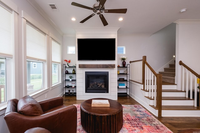 313 Parker St, North Little Rock, AR 72114 - living area with ceiling fan, dark wood-type flooring, stairs, crown molding, and a large fireplace