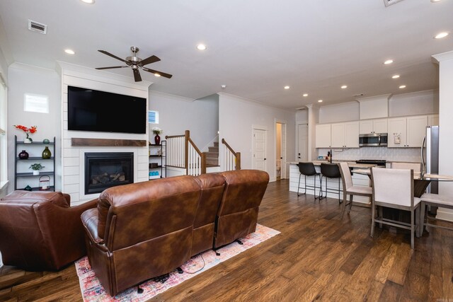 313 Parker St, North Little Rock, AR 72114 - living area with crown molding, ceiling fan, dark wood finished floors, stairs, and a large fireplace