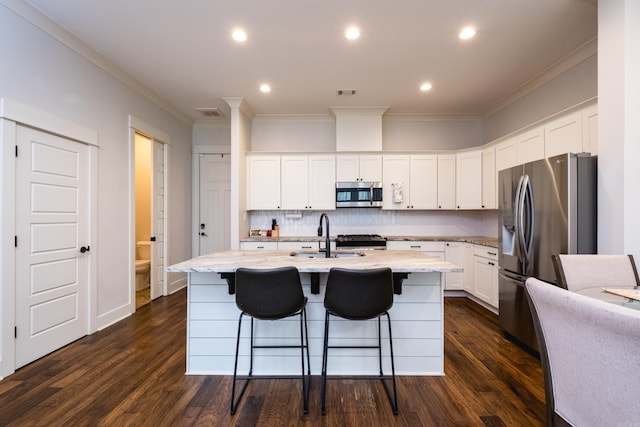 313 Parker St, North Little Rock, AR 72114 - kitchen featuring appliances with stainless steel finishes, a sink, ornamental molding, white cabinetry, and light stone counters