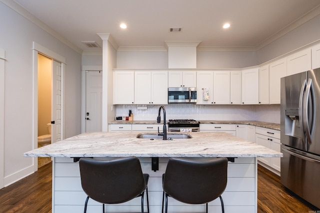 313 Parker St, North Little Rock, AR 72114 - kitchen with stainless steel appliances, ornamental molding, a sink, a kitchen bar, and an island with sink