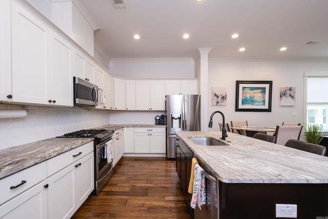 313 Parker St, North Little Rock, AR 72114 - kitchen with a sink, appliances with stainless steel finishes, crown molding, a kitchen island with sink, and light stone countertops