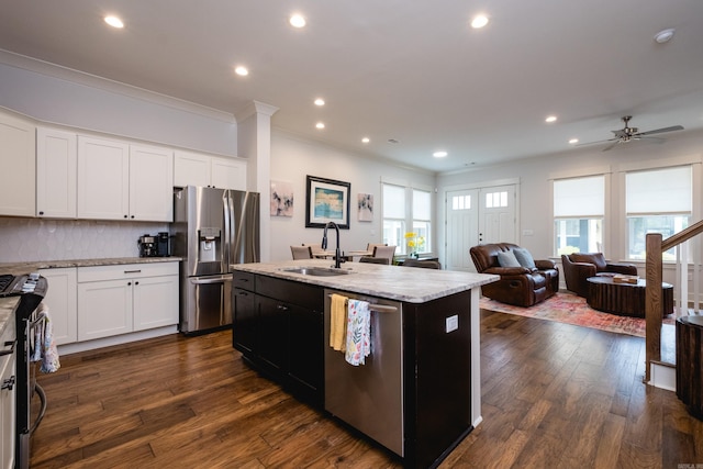 313 Parker St, North Little Rock, AR 72114 - kitchen with appliances with stainless steel finishes, a sink, ornamental molding, a center island with sink, and backsplash