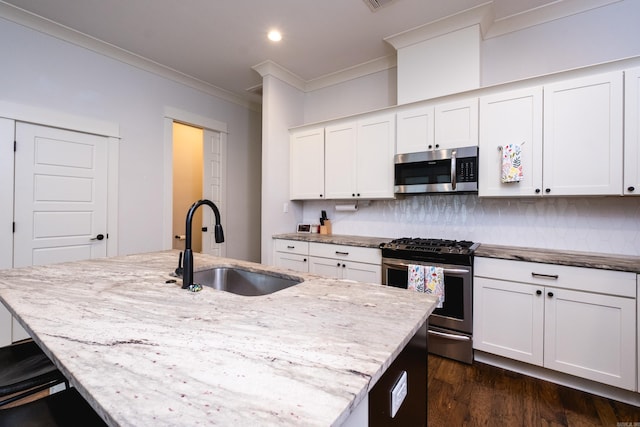 313 Parker St, North Little Rock, AR 72114 - kitchen featuring stainless steel appliances, a sink, ornamental molding, decorative backsplash, and light stone countertops