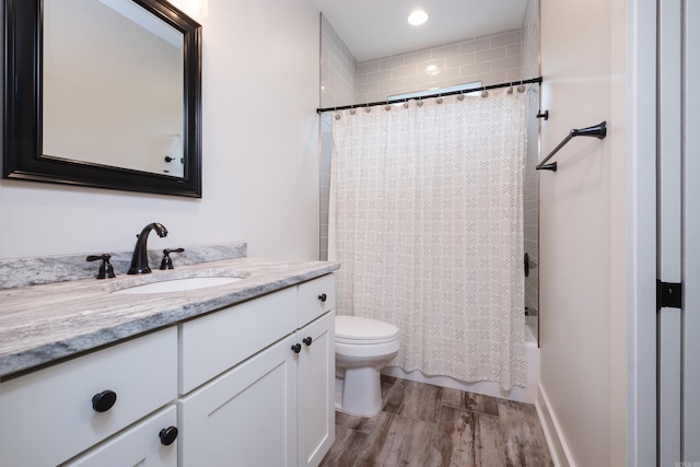 313 Parker St, North Little Rock, AR 72114 - bathroom featuring wood finished floors, vanity, toilet, shower / bath combo with shower curtain, and recessed lighting