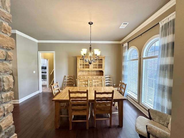 dining room with a chandelier, dark wood-style flooring, crown molding, and baseboards