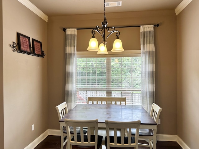 dining room with a chandelier, plenty of natural light, baseboards, ornamental molding, and dark wood-style floors
