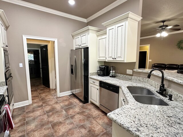 kitchen featuring appliances with stainless steel finishes, a sink, baseboards, crown molding, and a ceiling fan