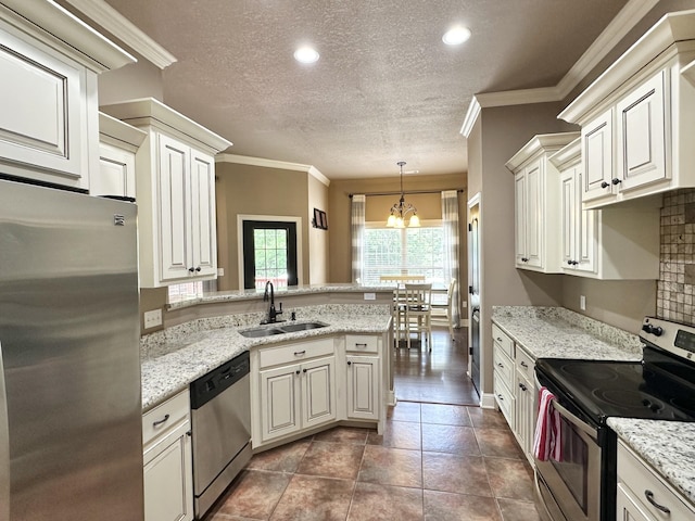 kitchen with stainless steel appliances, a sink, a peninsula, a chandelier, and a textured ceiling