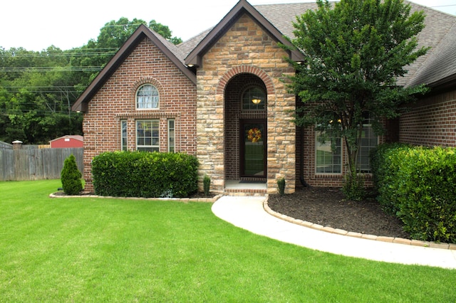 tudor house featuring brick siding and roof with shingles