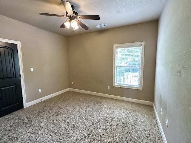empty room featuring ceiling fan, carpet, and baseboards