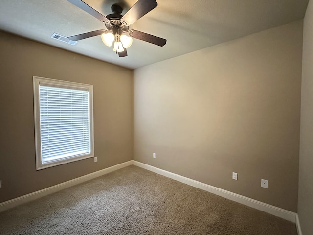 spare room with carpet floors, a ceiling fan, and baseboards
