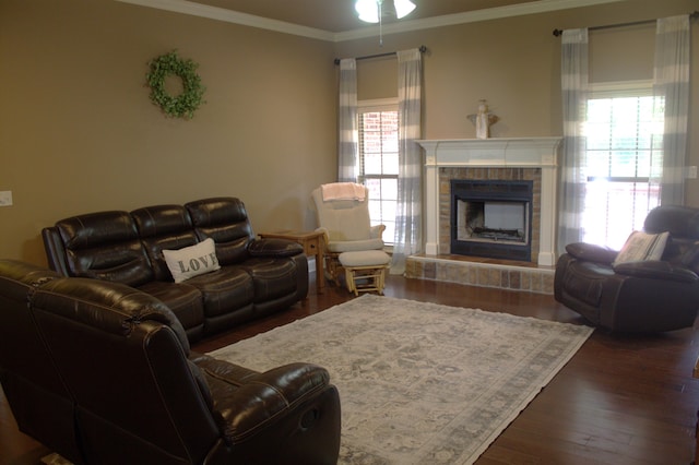 living room with crown molding, a tile fireplace, wood finished floors, and ceiling fan