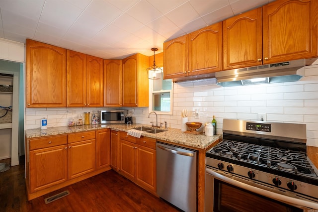 10111 Kling Rd, Mabelvale, AR 72103 - kitchen with stainless steel appliances, under cabinet range hood, a sink, light stone counters, and decorative backsplash
