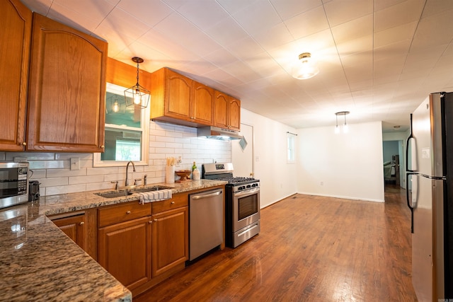 10111 Kling Rd, Mabelvale, AR 72103 - kitchen with appliances with stainless steel finishes, a sink, brown cabinetry, backsplash, and decorative light fixtures