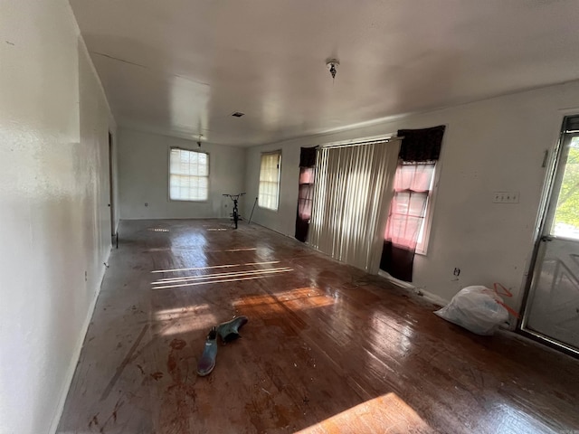 unfurnished living room with wood finished floors and baseboards